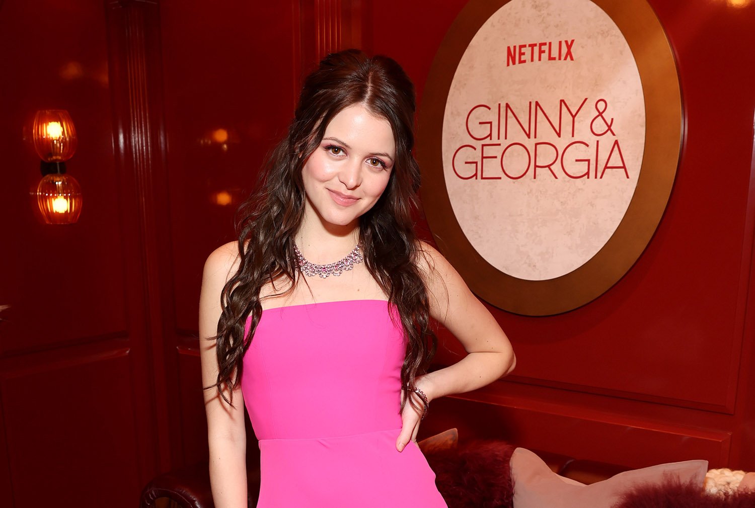 Ginny & Georgia star Sara Waisglass poses in a pink dress at a dinner to celebrate season 2