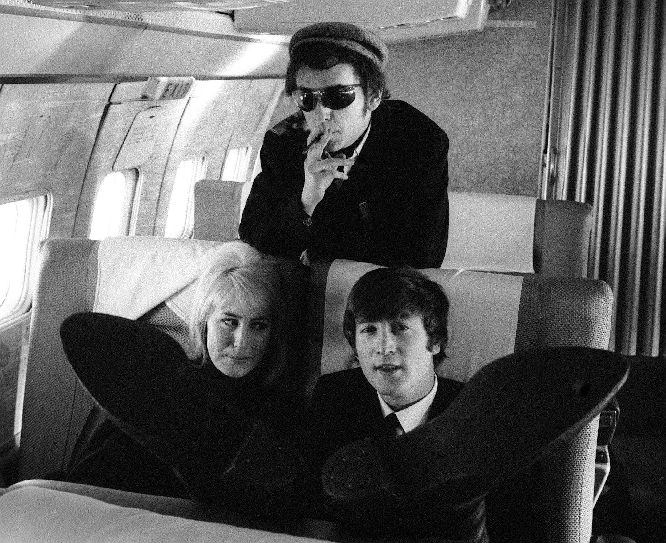 Phil Spector, John Lennon, and Cynthia Lennon in black-and-white during The Beatles' "The Long and Winding Road" era