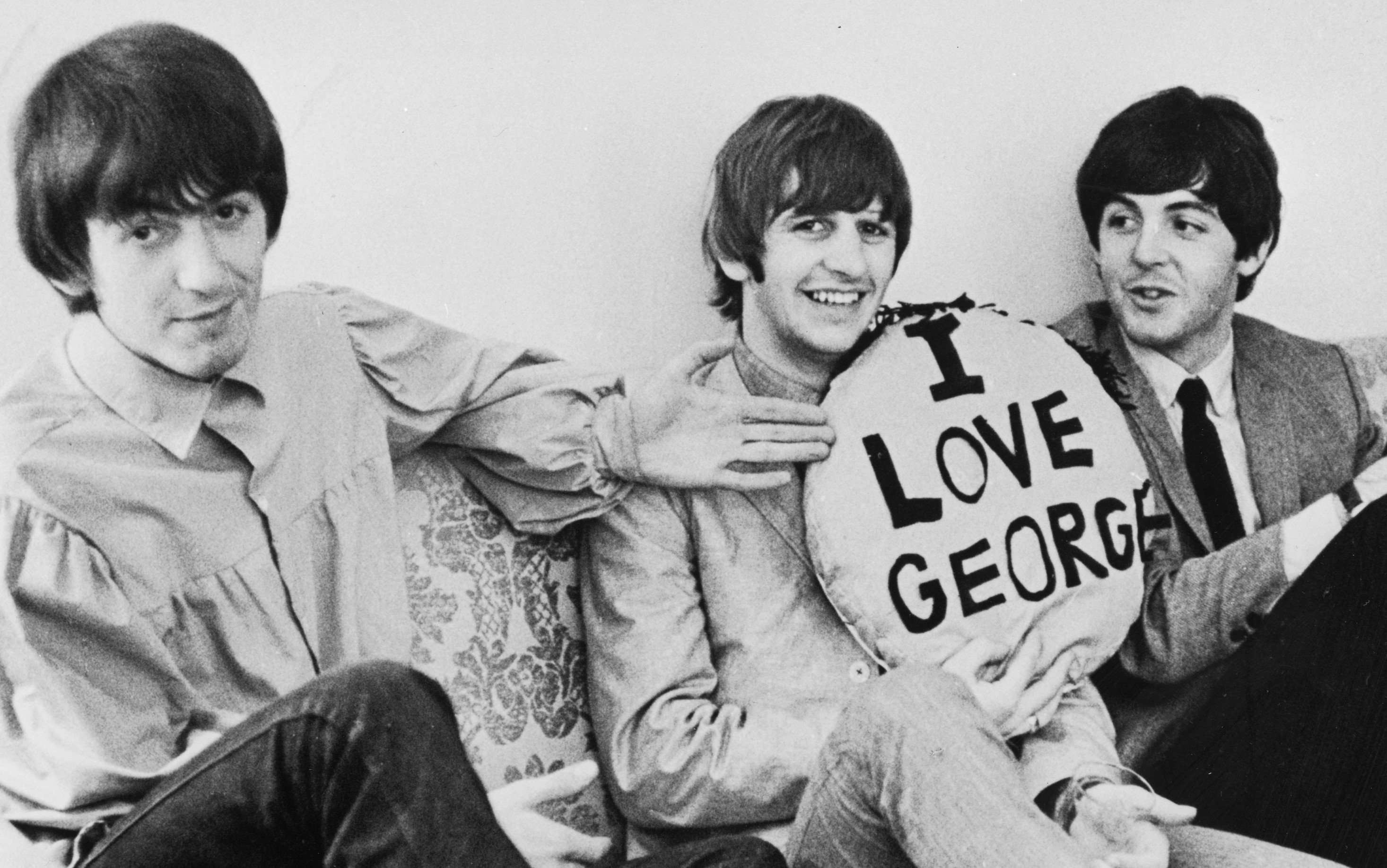 The Beatles' George Harrison, Ringo Starr, and Paul McCartney with a pillow