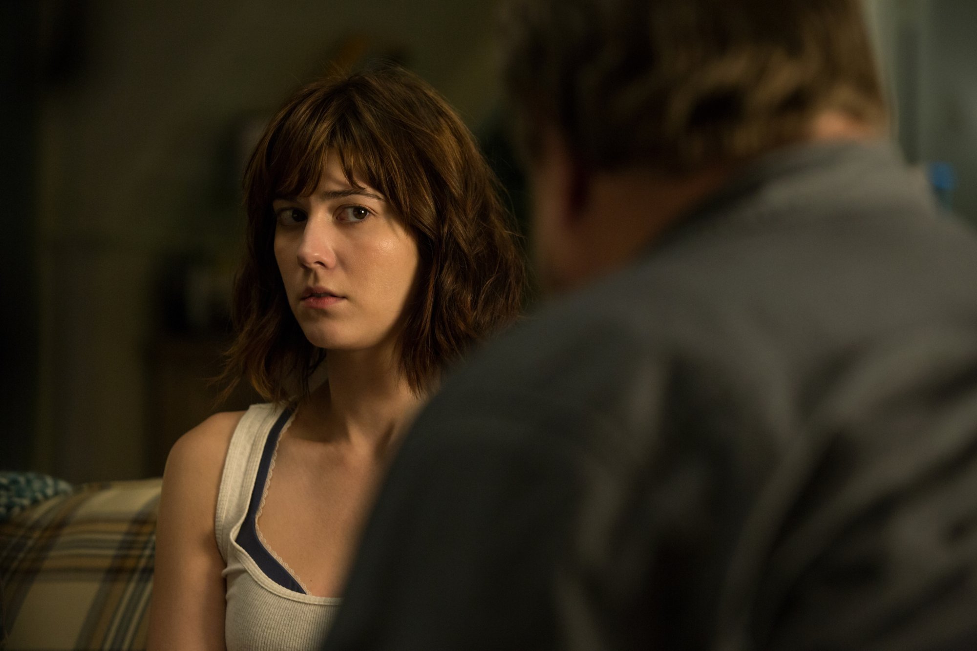 '10 Cloverfield Lane' Mary Elizabeth Winstead as Michelle looking scared in front of John Goodman's silhouette.