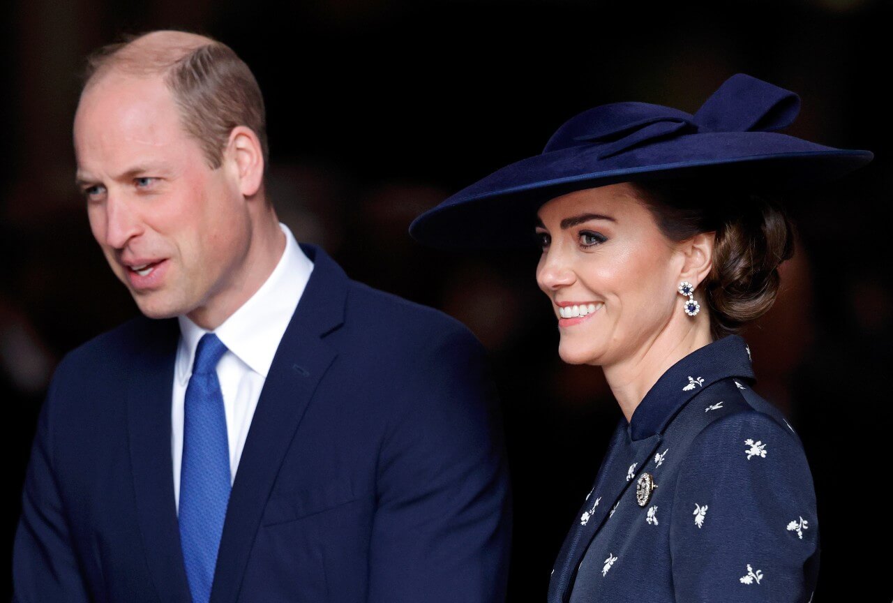 Prens William ve Kate Middleton yan yana dururken gülümsüyorlar. 