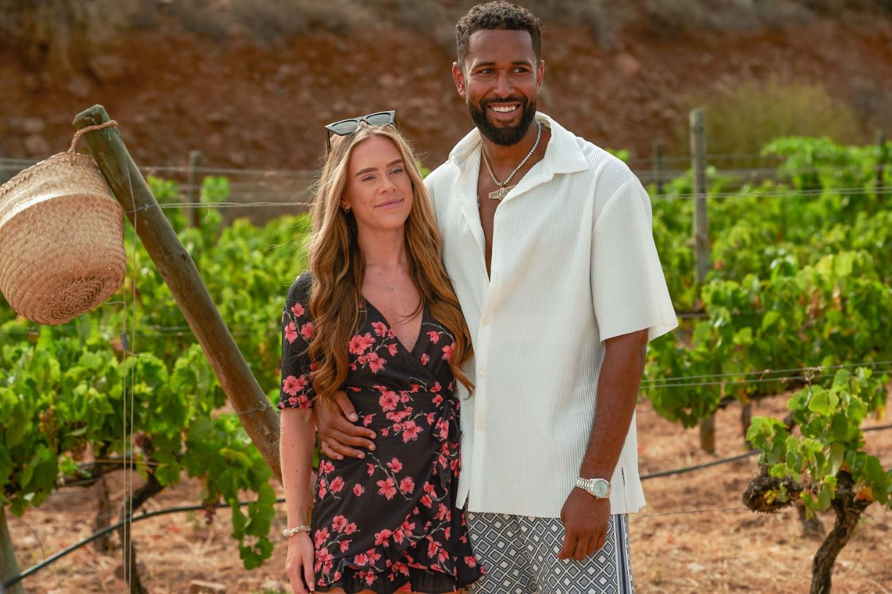 Courtney Rowe and Nathan Grant go on a date in 'Are You the One?' Season 9 on Paramount+. Courtney wears a black dress with pink flowers. Nathan wears a white short-sleeve button-up shirt and gray shorts.