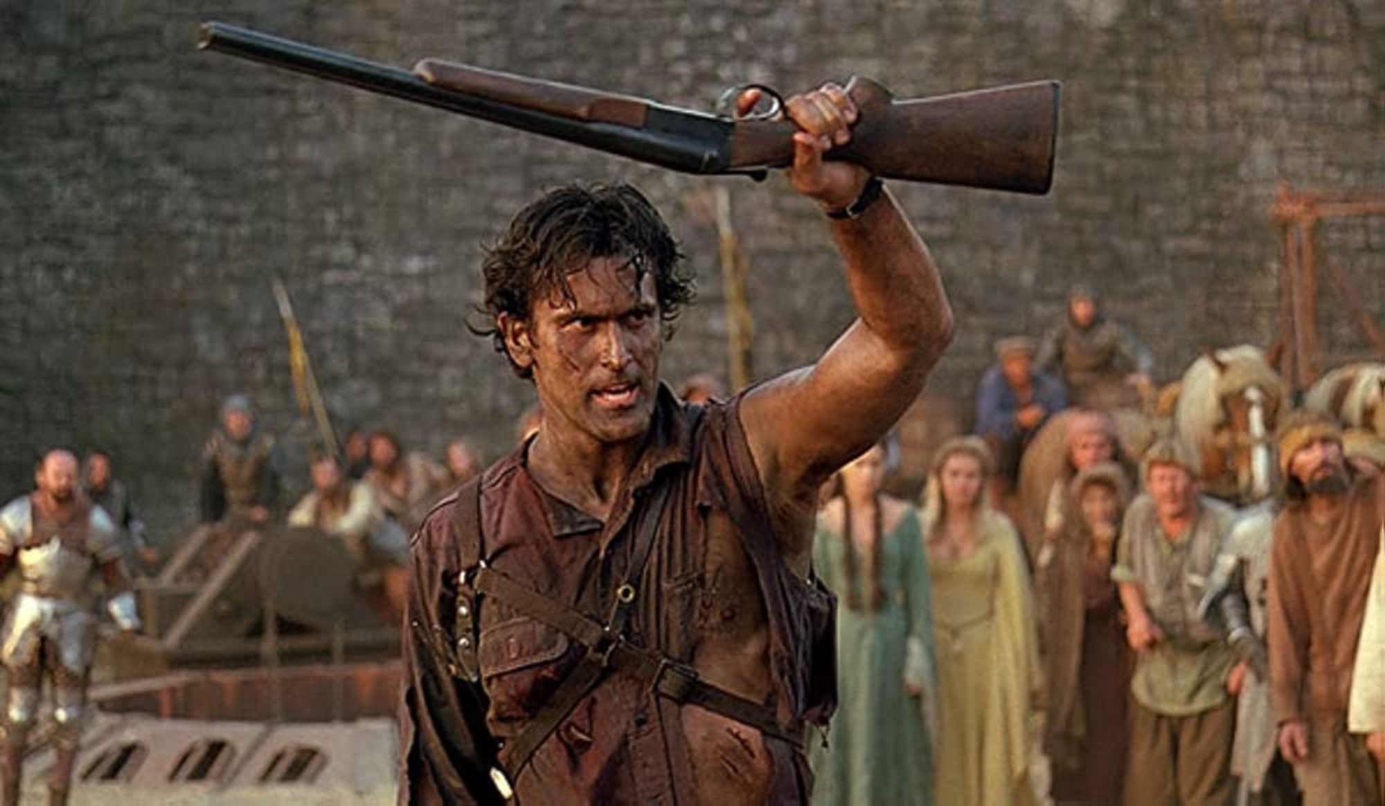 'Army of Darkness' Bruce Campbell as Ash Williams holding up his shotgun in a crowd of people.