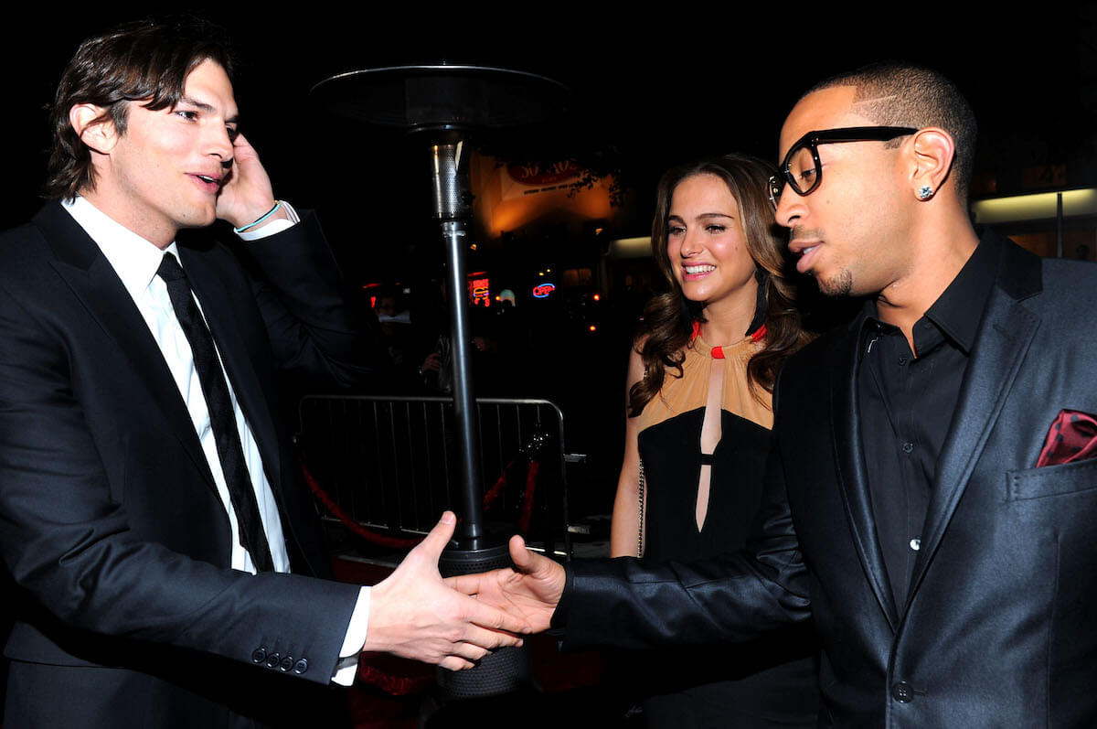 Ashton Kutcher shaking hands with Ludacris with Natalie Portman watching