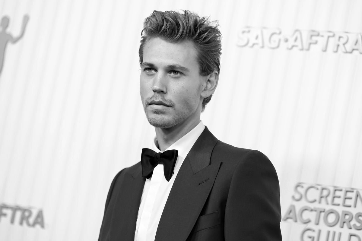 Austin Butler poses for photos at the SAG awards in a black and white photo.