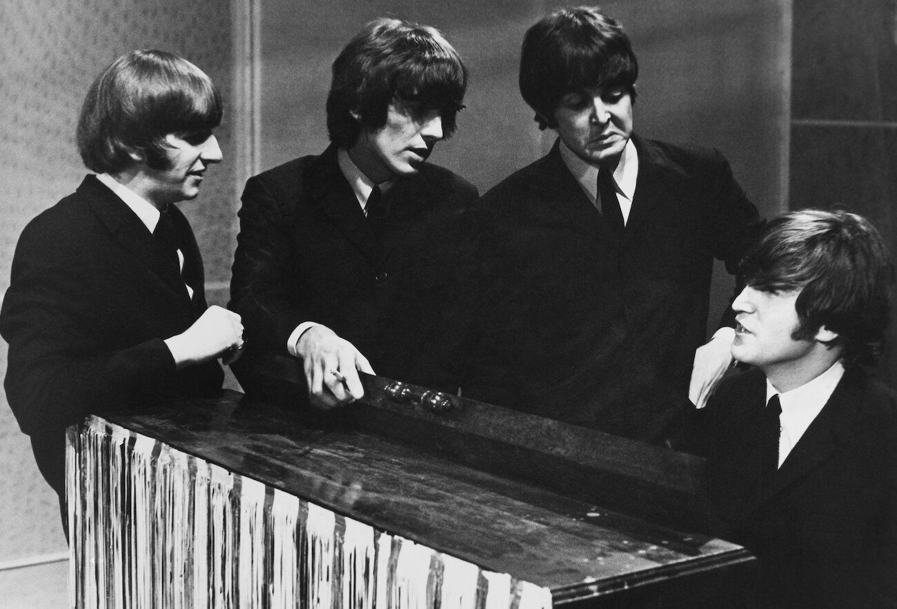 The Beatles, some of the best writers of love songs, standing around a piano in 1965.