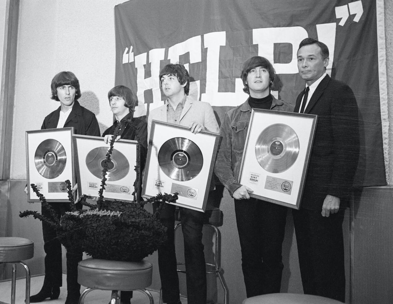 Beatles members George Harrison (from left), Ringo Starr, Paul McCartney, and John Lennon display gold records while promoting the movie 'Help!' in 1965.
