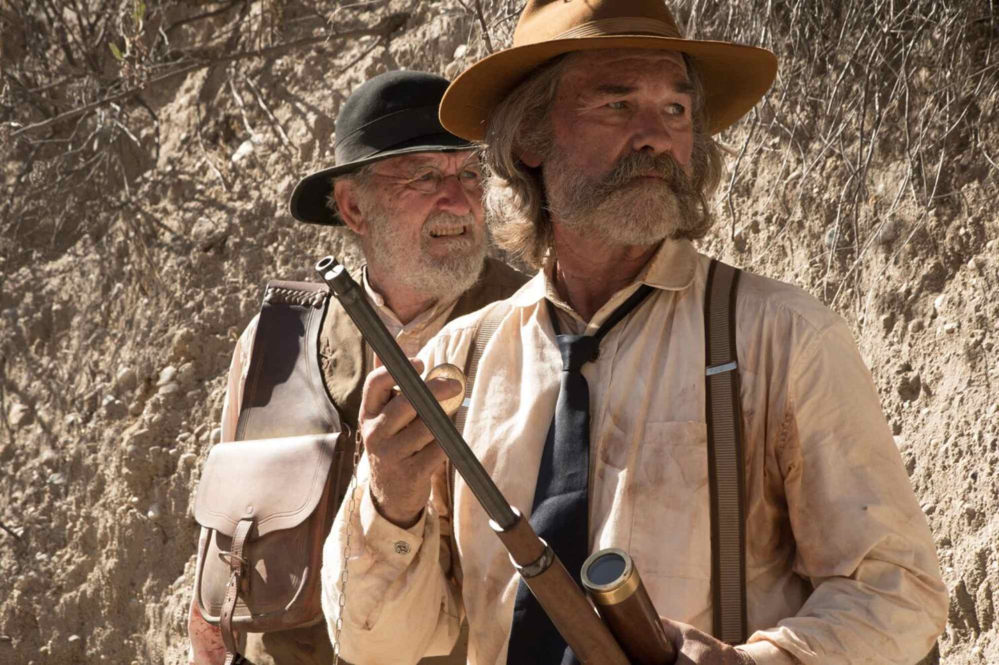 'Bone Tomahawk' Richard Jenkins as Chicory and Kurt Russell as Sheriff Hunt. Russell holding a rifle and Jenkins standing behind him.