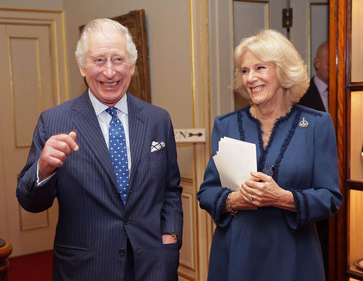 Britain's King Charles III and Camilla, Queen Consort share a joke at a reception at Clarence House