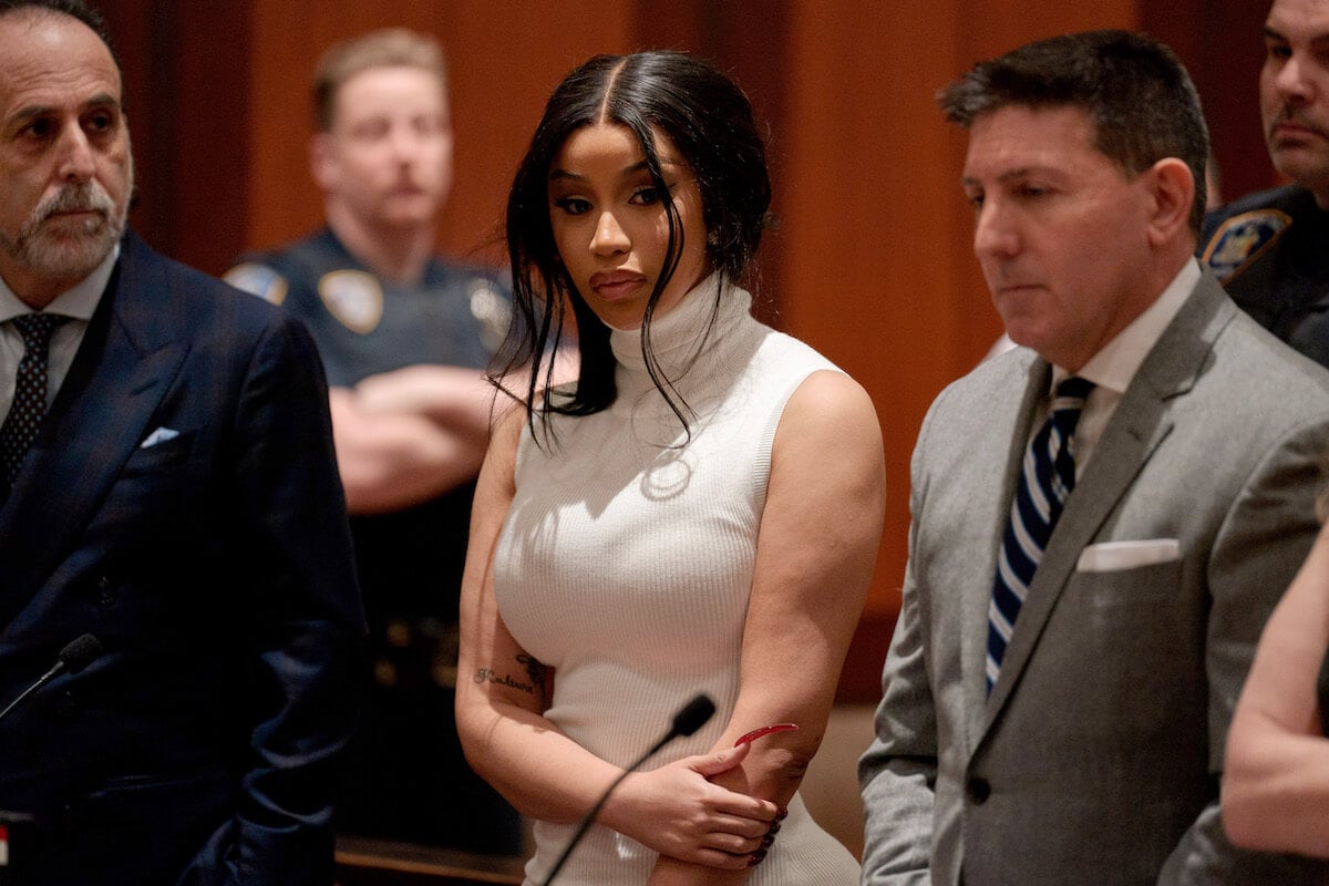 Cardi B standing in court wearing a white dress