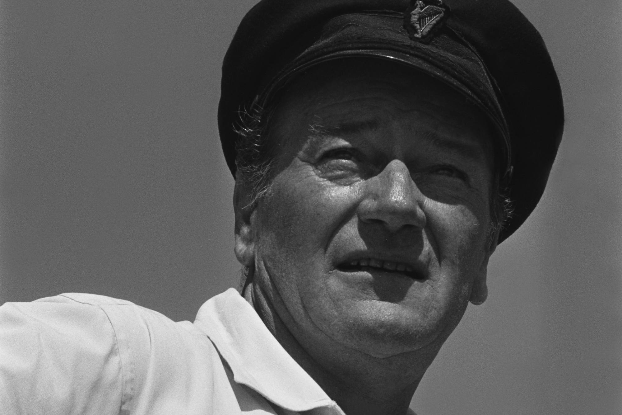 Career actor John Wayne wearing a Navy outfit and a white collared shirt