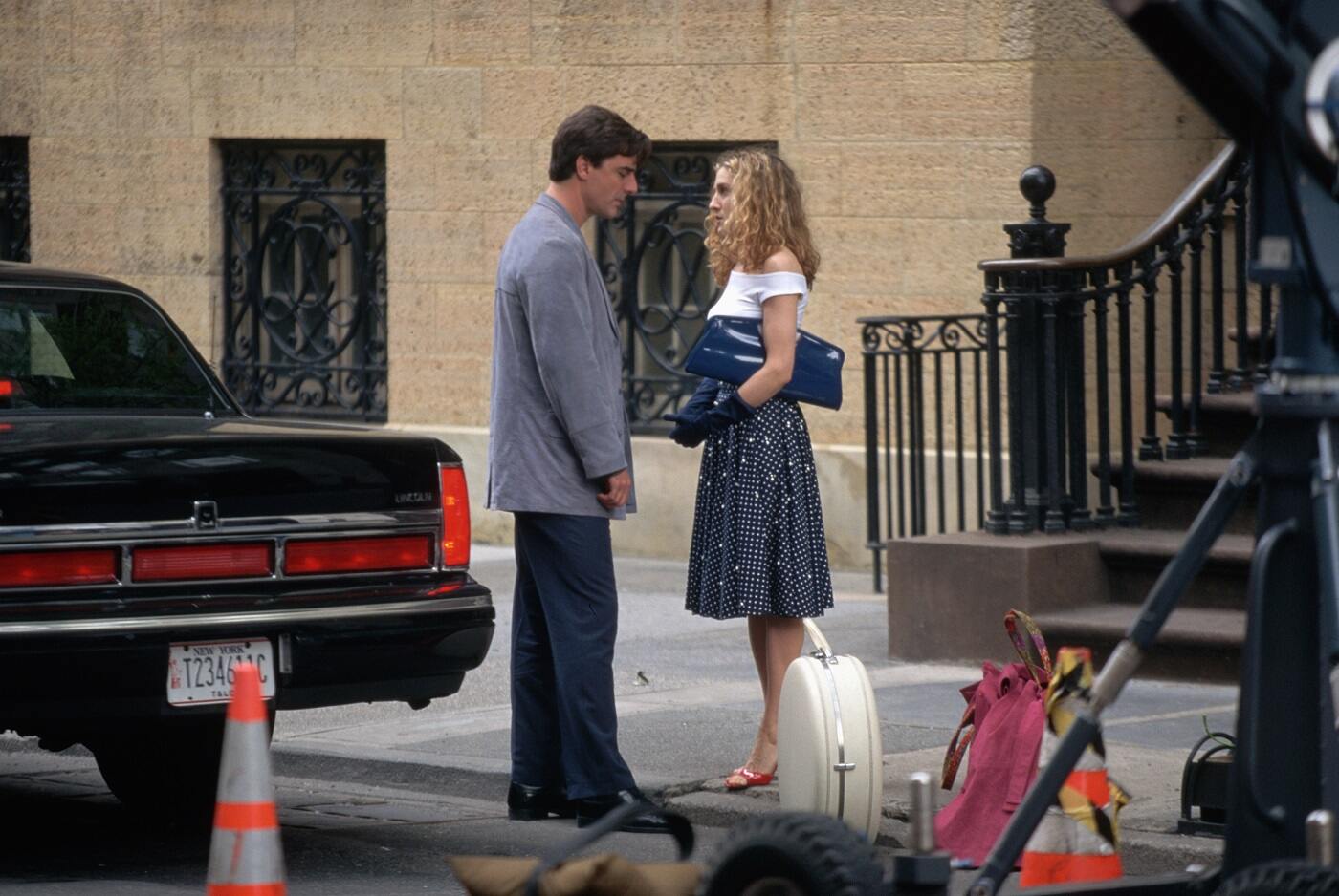 Chris Noth as Mr. Big and Sarah Jessica Parker as Carrie Bradshaw stand in front of her apartment in season 1 of 'Sex and the City'