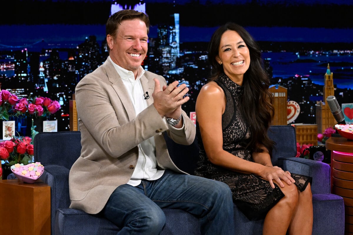 Chip and Joanna Gaines sit together and smile on a talk show.