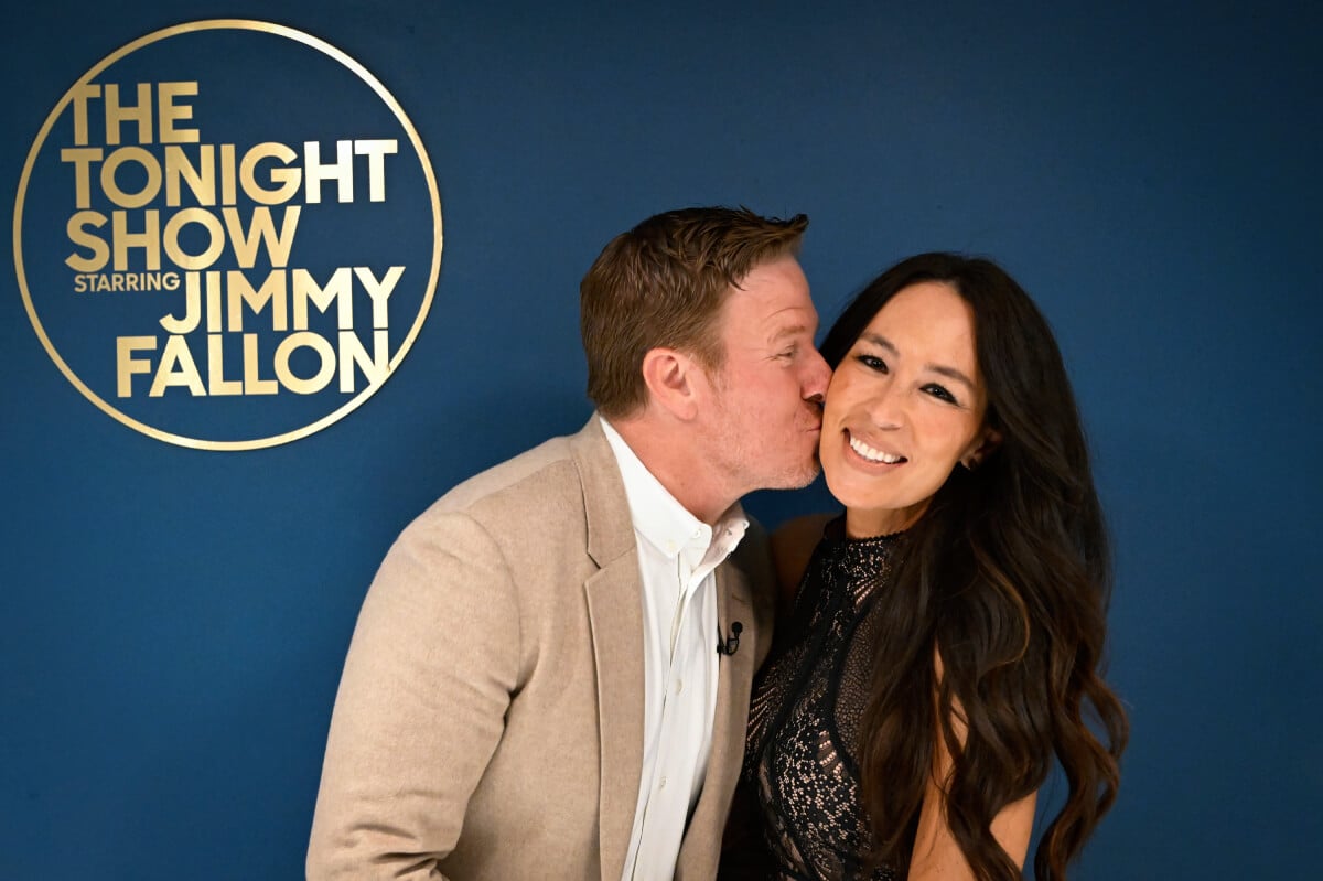 TV personalities Chip Gaines and Joanna Gaines pose together backstage at The Tonight Show Starring Jimmy Fallon. Chip kisses Joanna on the cheek.
