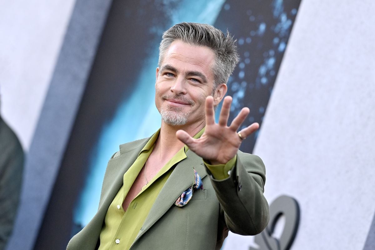Chris Pine waves to the camera at a film premiere event.