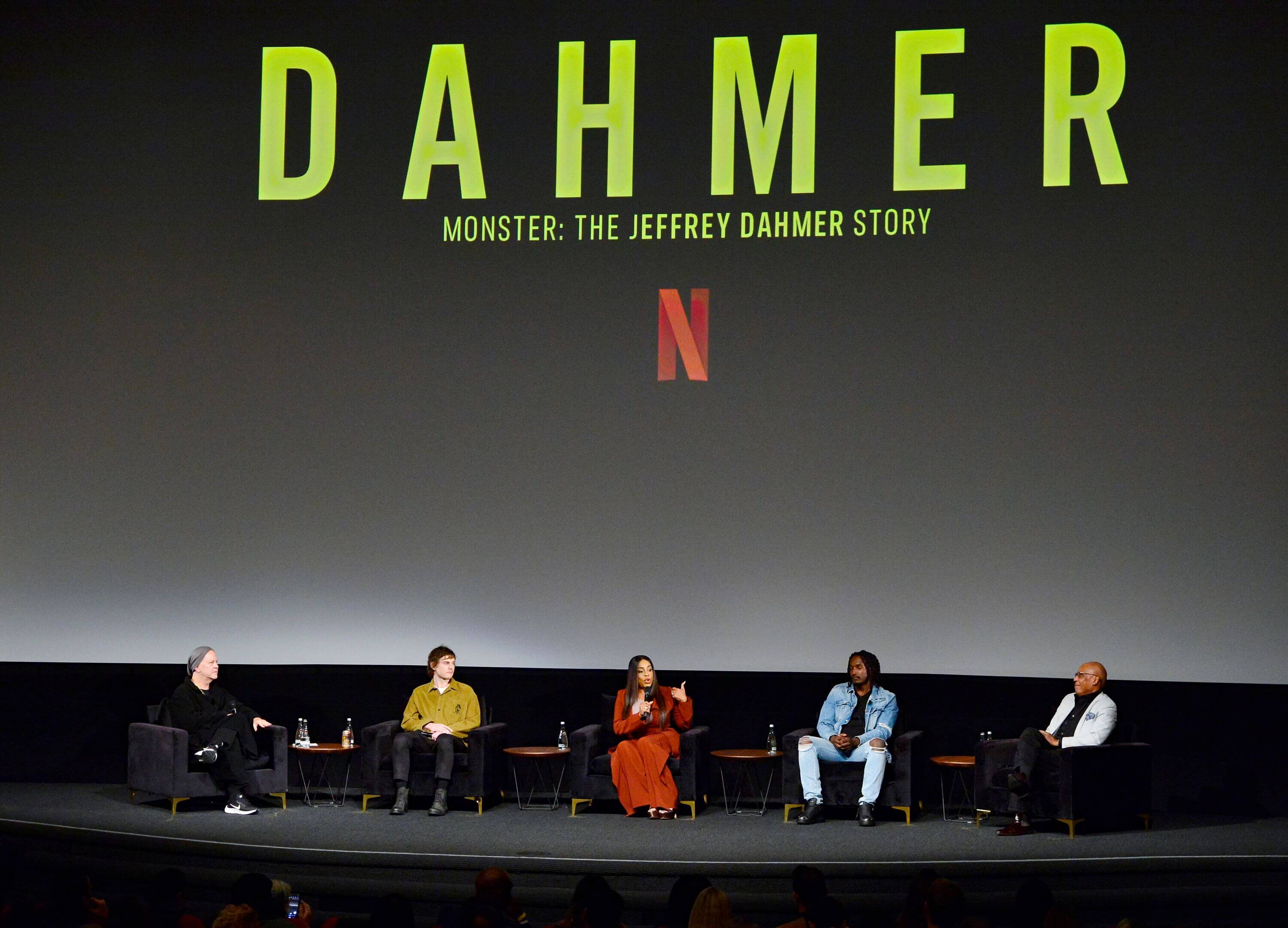 The cast of Netflix's 'Dahmer — Monster: The Jeffrey Dahmer Story' sitting on a stage