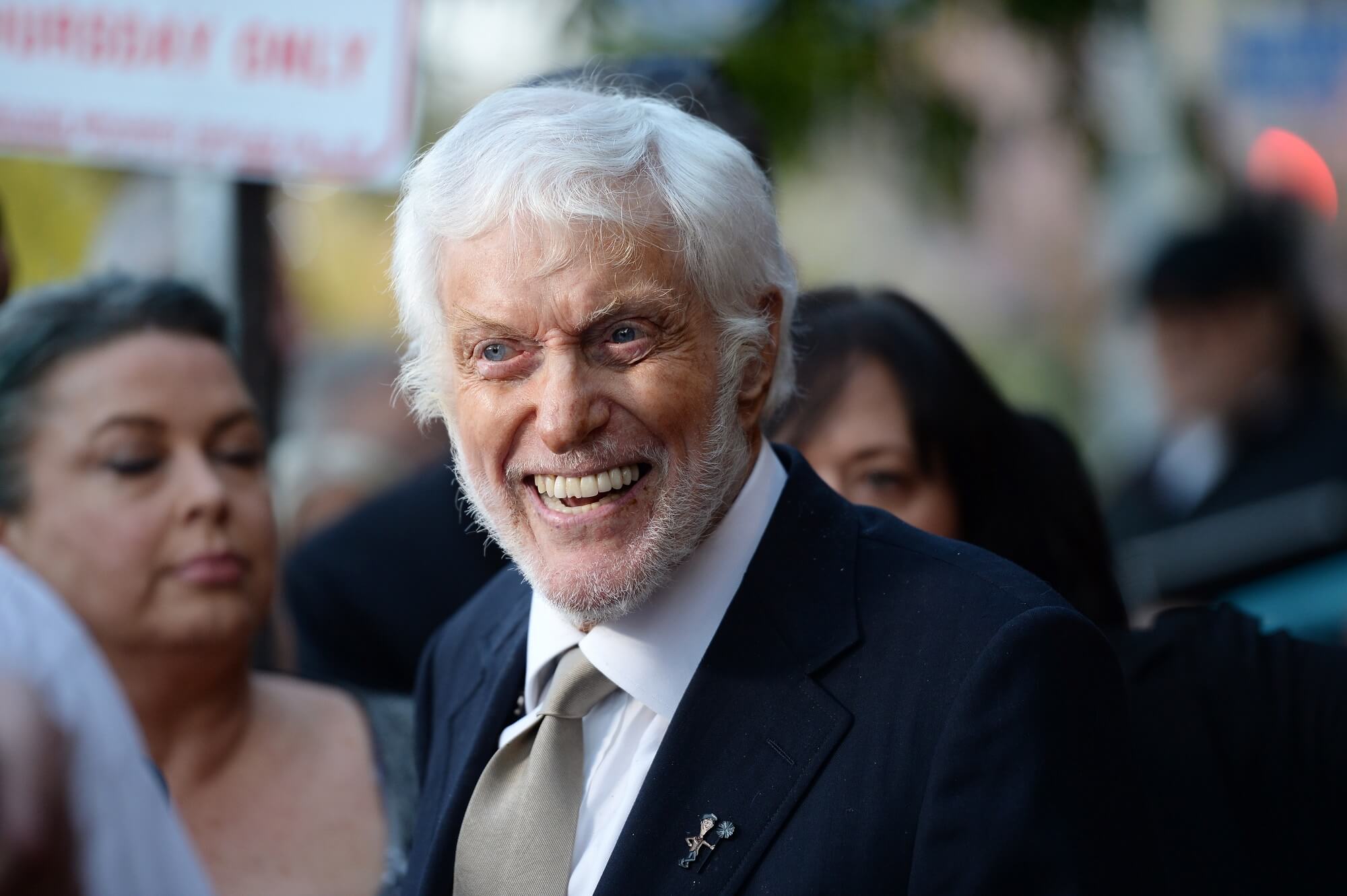 Dick Van Dyke smiles while outside and surrounded by people