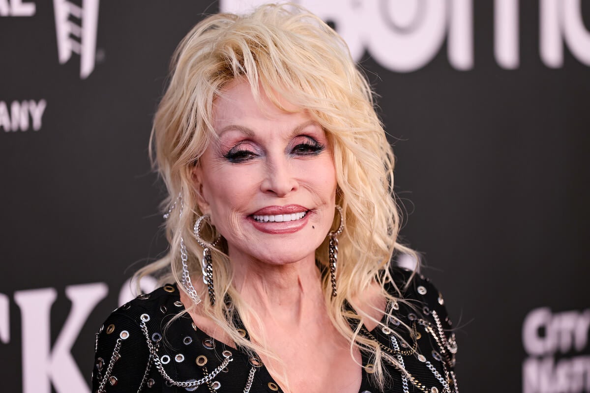 Dolly Parton smiles and poses at an event.