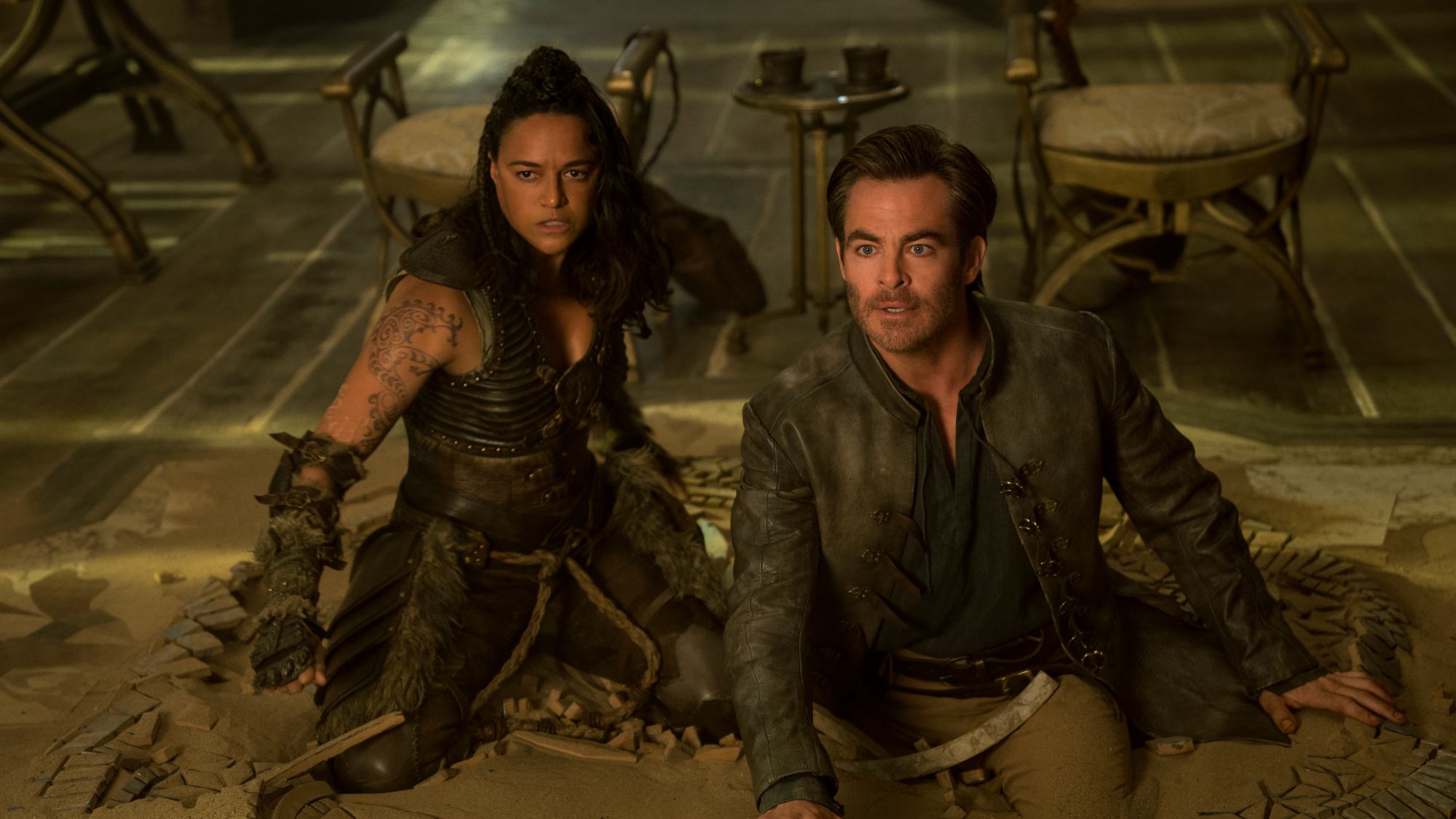 'Dungeons & Dragons: Honor Among Thieves' Chris Pine as Edgin and Michelle Rodriguez as Holga sunken into the ground looking frustrated.