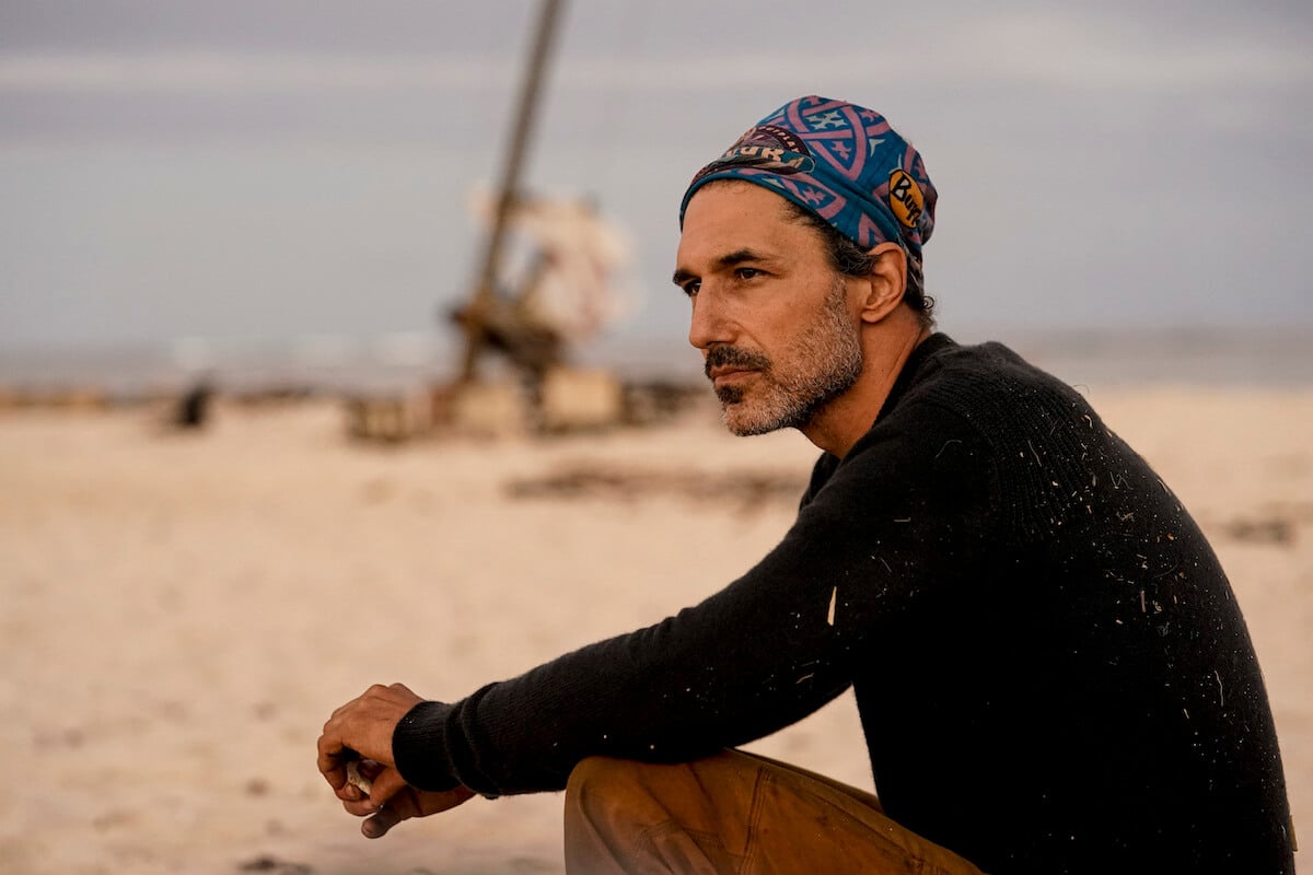 Ethan Zohn sitting looking off on in a scene in 'Survivor: Winners at War'