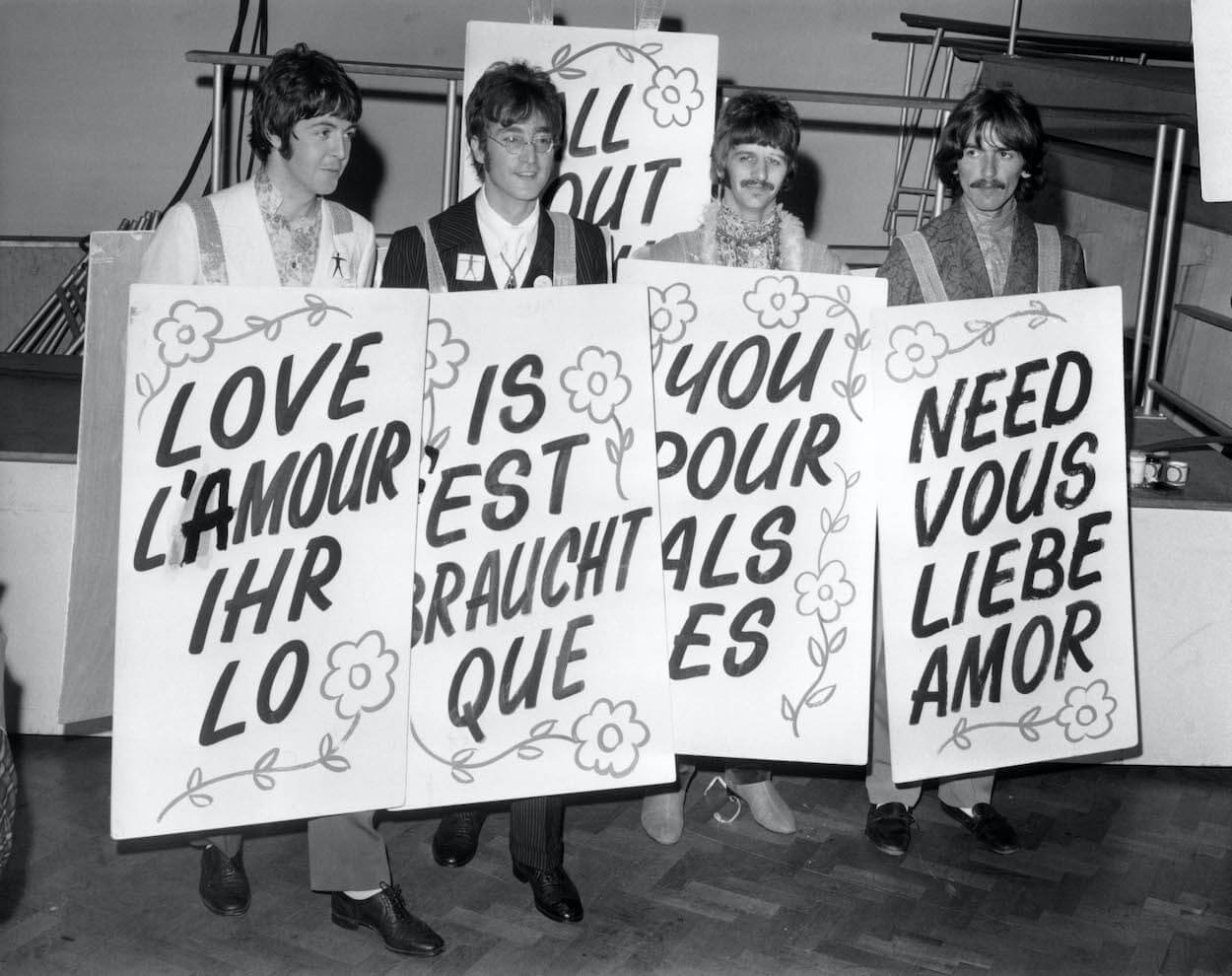 Beatles members (from left) Paul McCartney, John Lennon, Ringo Starr, and George Harrison wear sandwich boards while promoting the song 'All You Need Is Love.'
