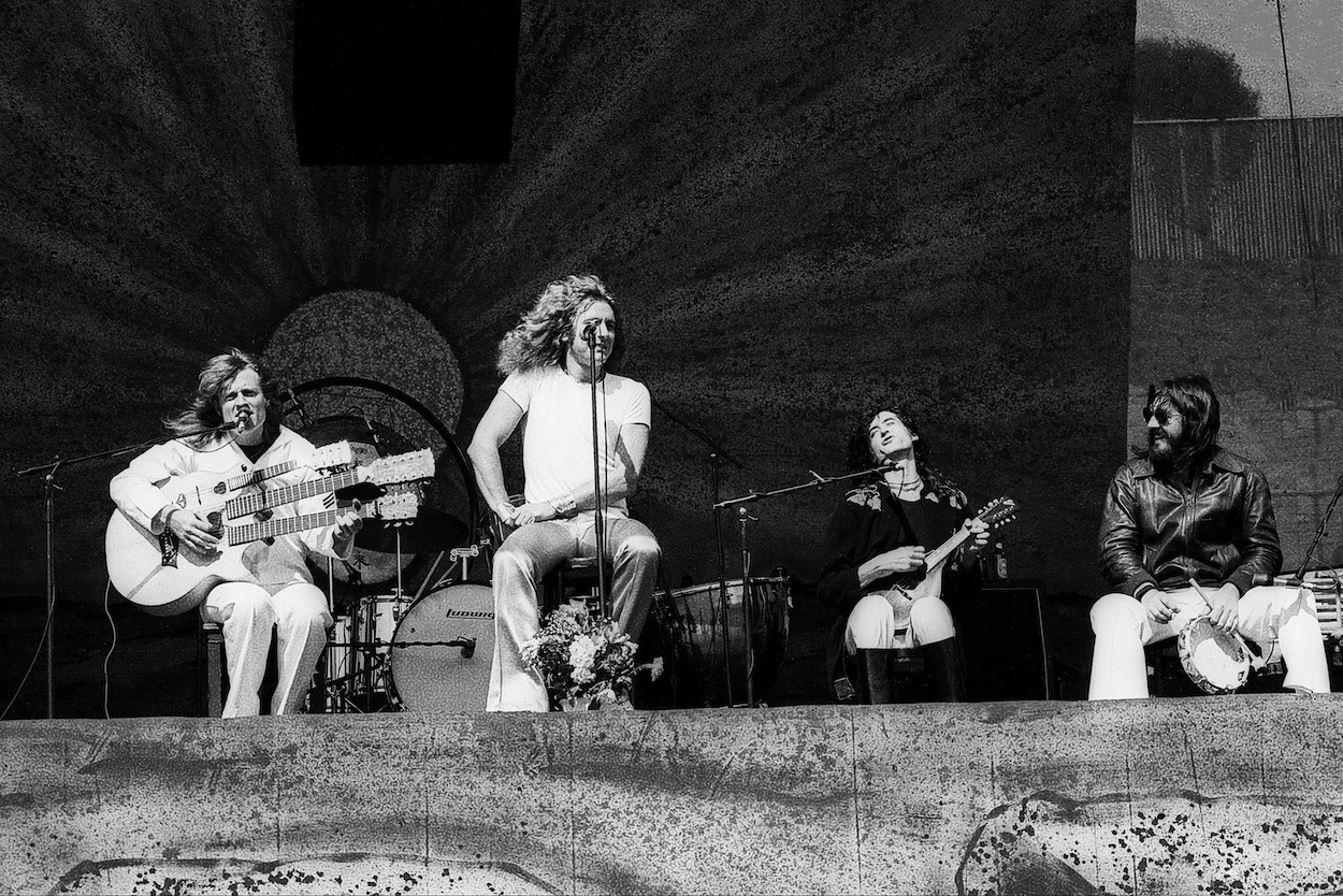 Led Zeppelin members (from left) John Paul Jones, Robert Plant, Jimmy Page, and John Bonham sit during an acoustic portion of a 1977 concert.