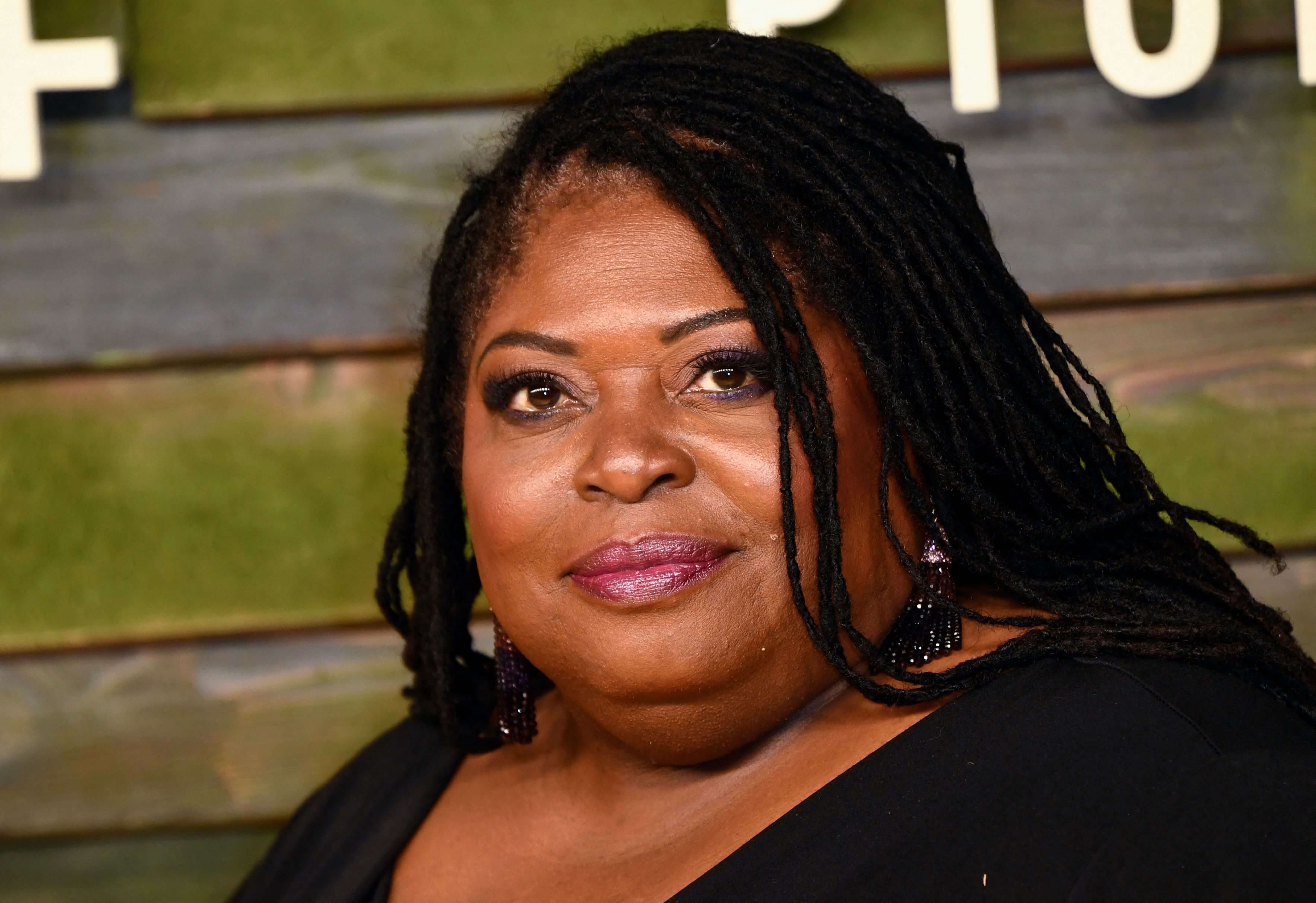 'General Hospital' star Sonya Eddy in a black dress, poses on the red carpet.