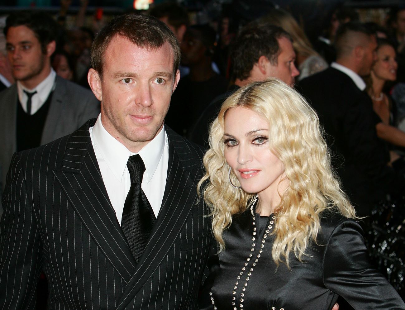 Guy Ritchie and Madonna both wear black and stand together in a crowd.