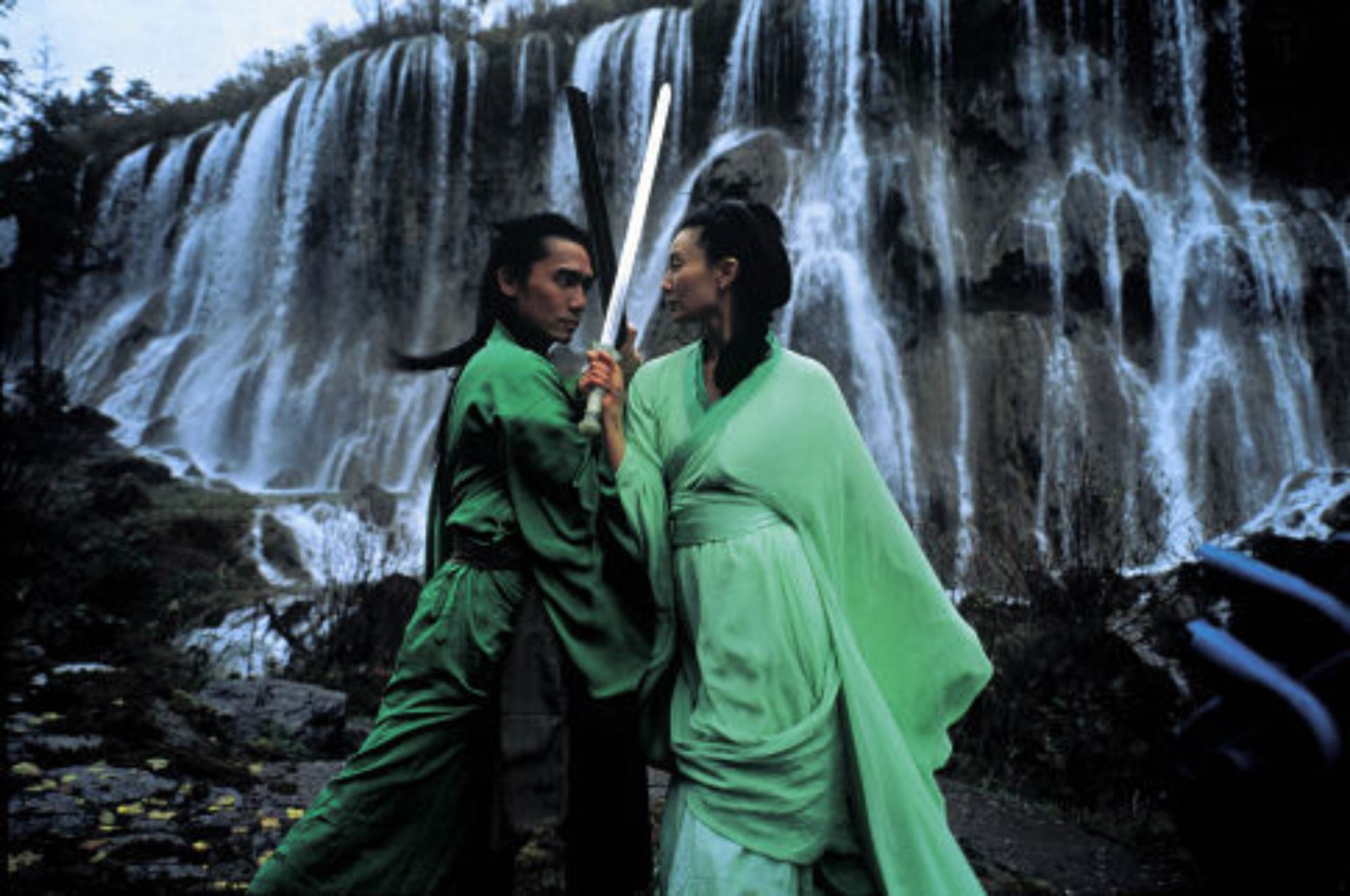 'Hero' Maggie Cheung as Flying Snow as and Tony Leung Chiu-wai as Broken Sword locking eyes in combat in front of a waterfall