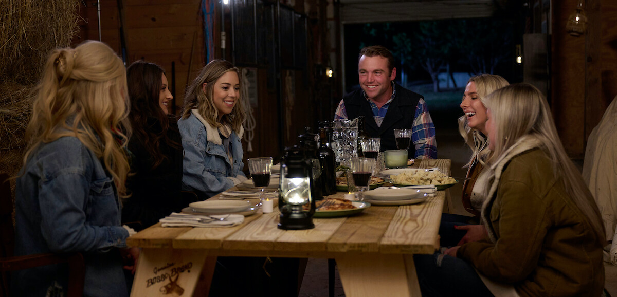 'Farmer Wants a Wife' cast member Hunter sitting at a table with several women