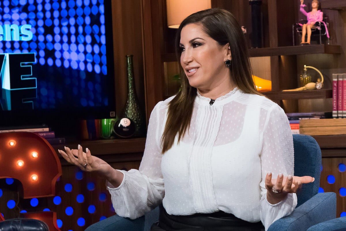 Jacqueline Laurita sitting with her palms facing up like she's talking