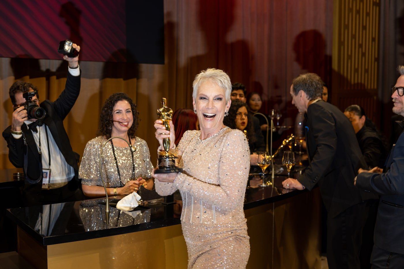 Jamie Lee Curtis smiles and holds her Academy Award