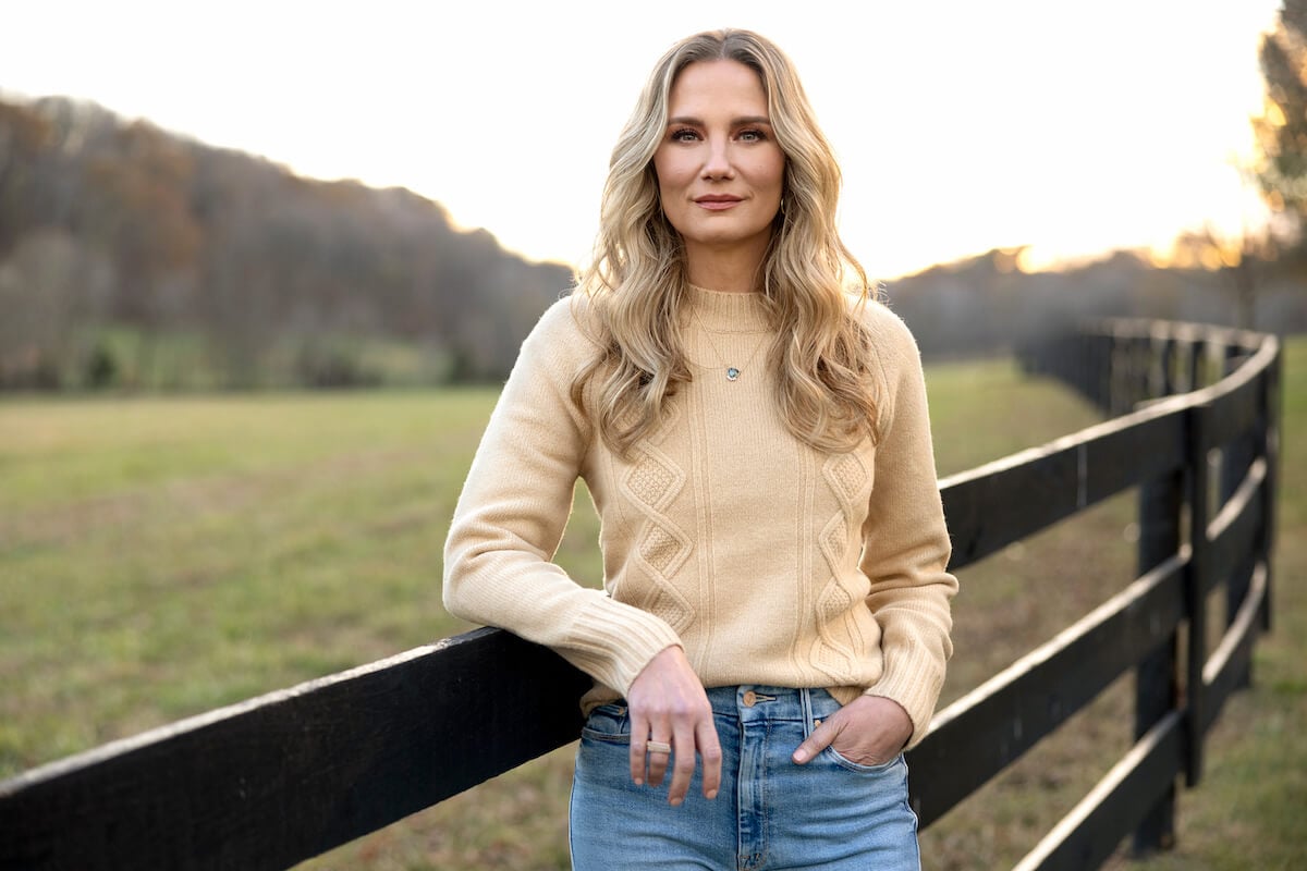 'Farmer Wants a Wife' host Jennifer Nettles standing next to a fence