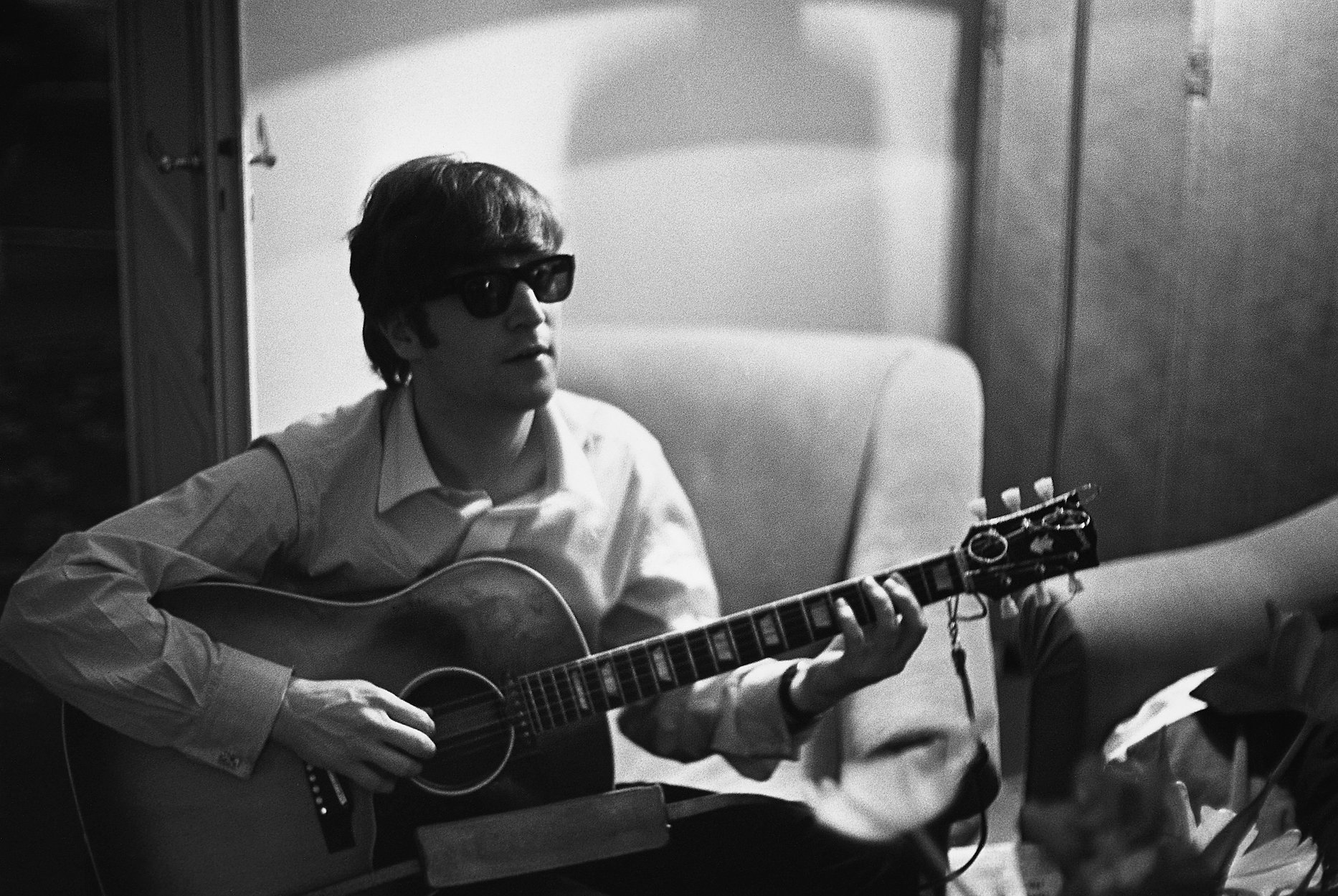 John Lennon of The Beatles plays the guitar in Paris