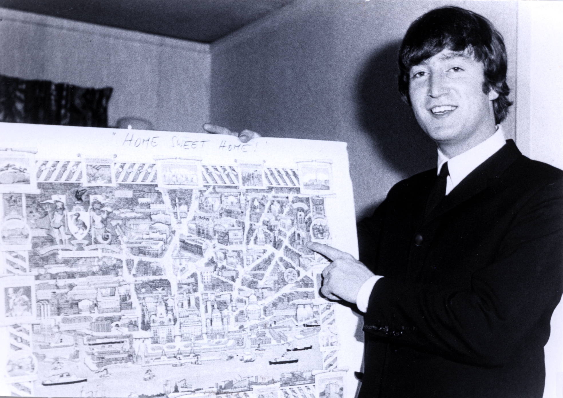 John Lennon of The Beatles points to a map of Liverpool