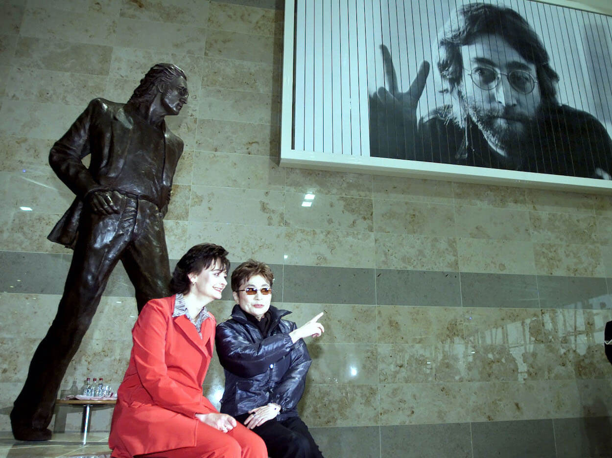Cherie Booth (left) wears red as she and Yoko Ono, dressed in black, sit at the feet of the John Lennon statue in Liverpool Airport.