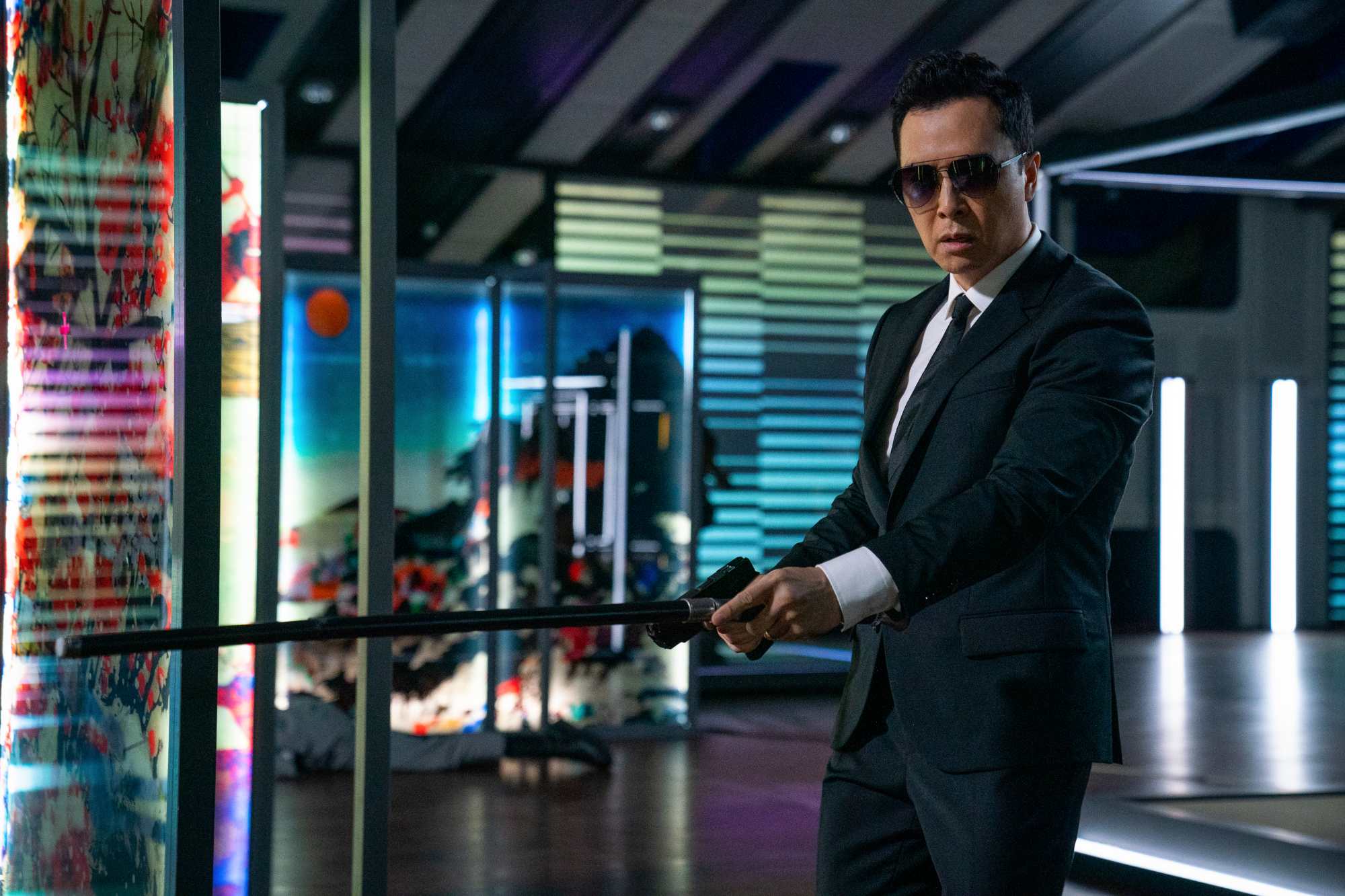 'John Wick_ Chapter 4' Donnie Yen as Caine wearing glasses, holding out a blind cane