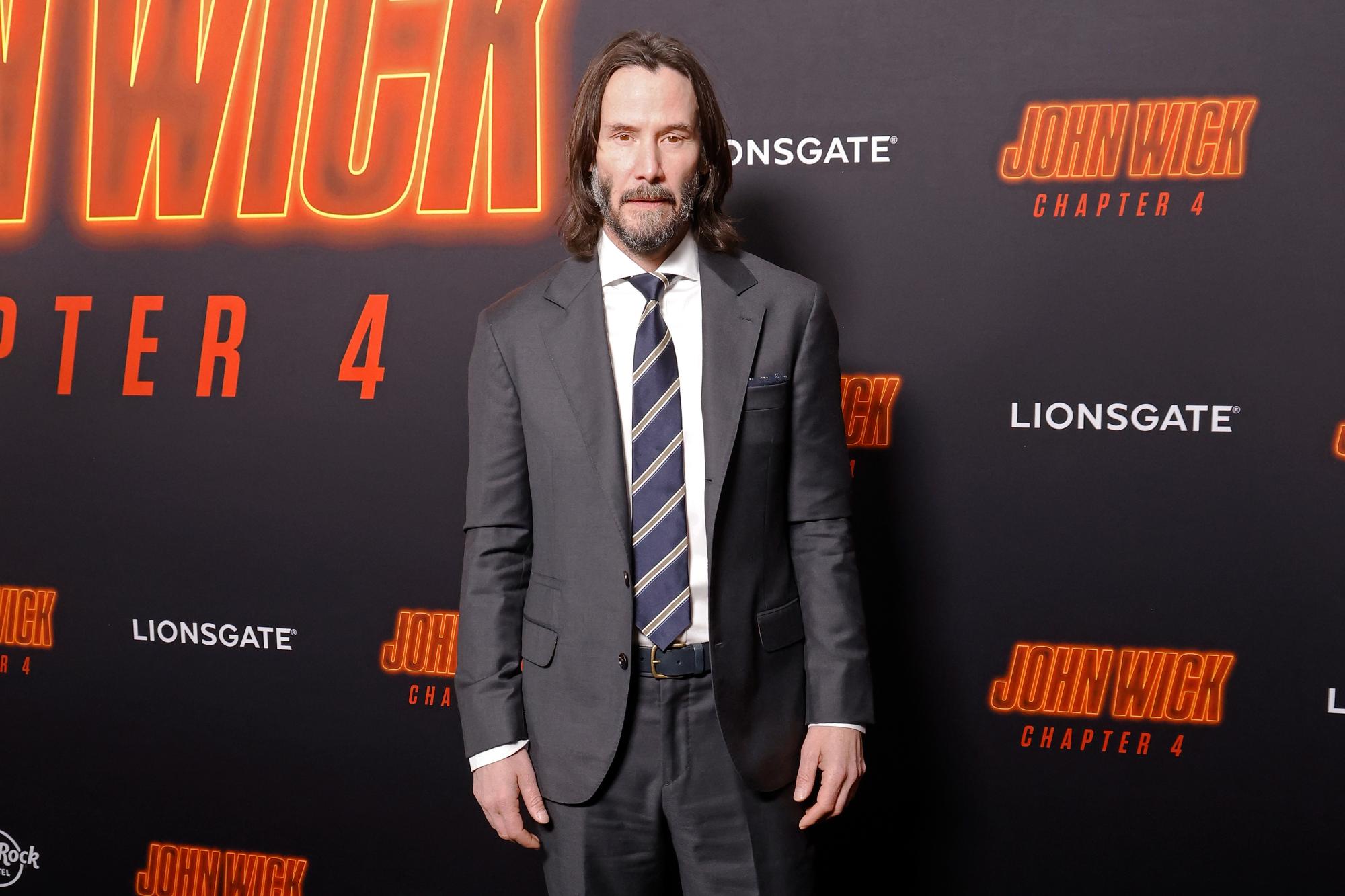 'John Wick: Chapter 4' star Keanu Reeves, who kept props. He's wearing a suit and tie in front of a step and repeat.