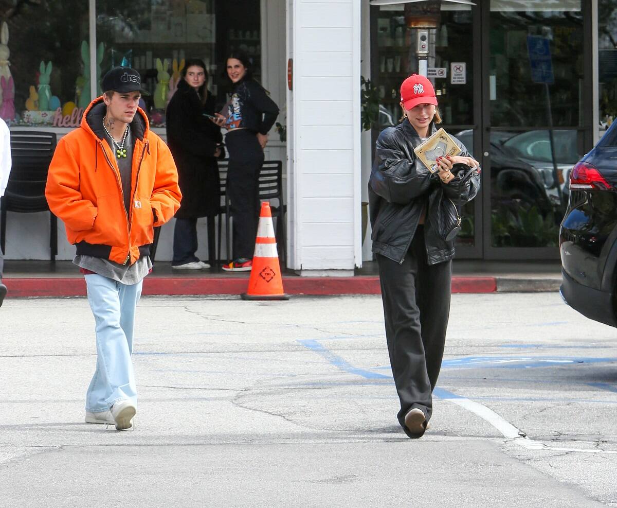 Justin Bieber and Hailey Bieber are seen walking through a parking lot together amid the Selena Gomez/Hailey Bieber drama