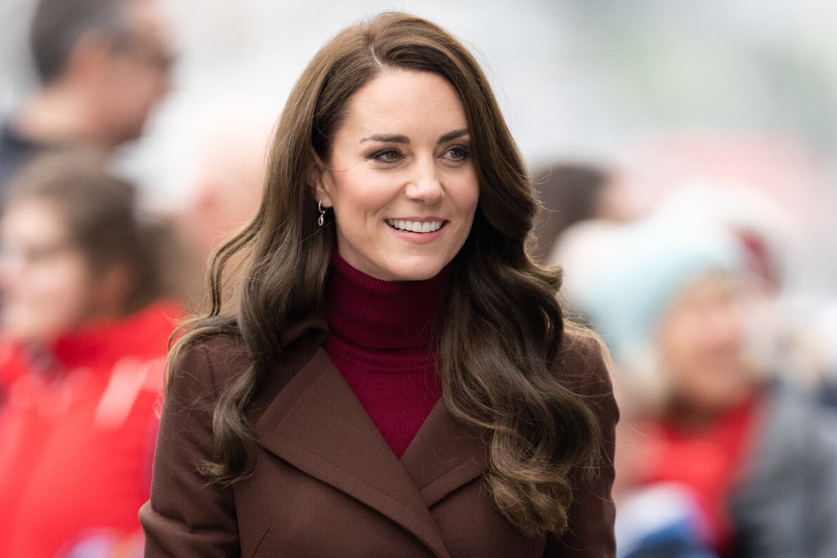 Kate Middleton, whose fashion conundrum includes wearing Zara items, smiles and looks on