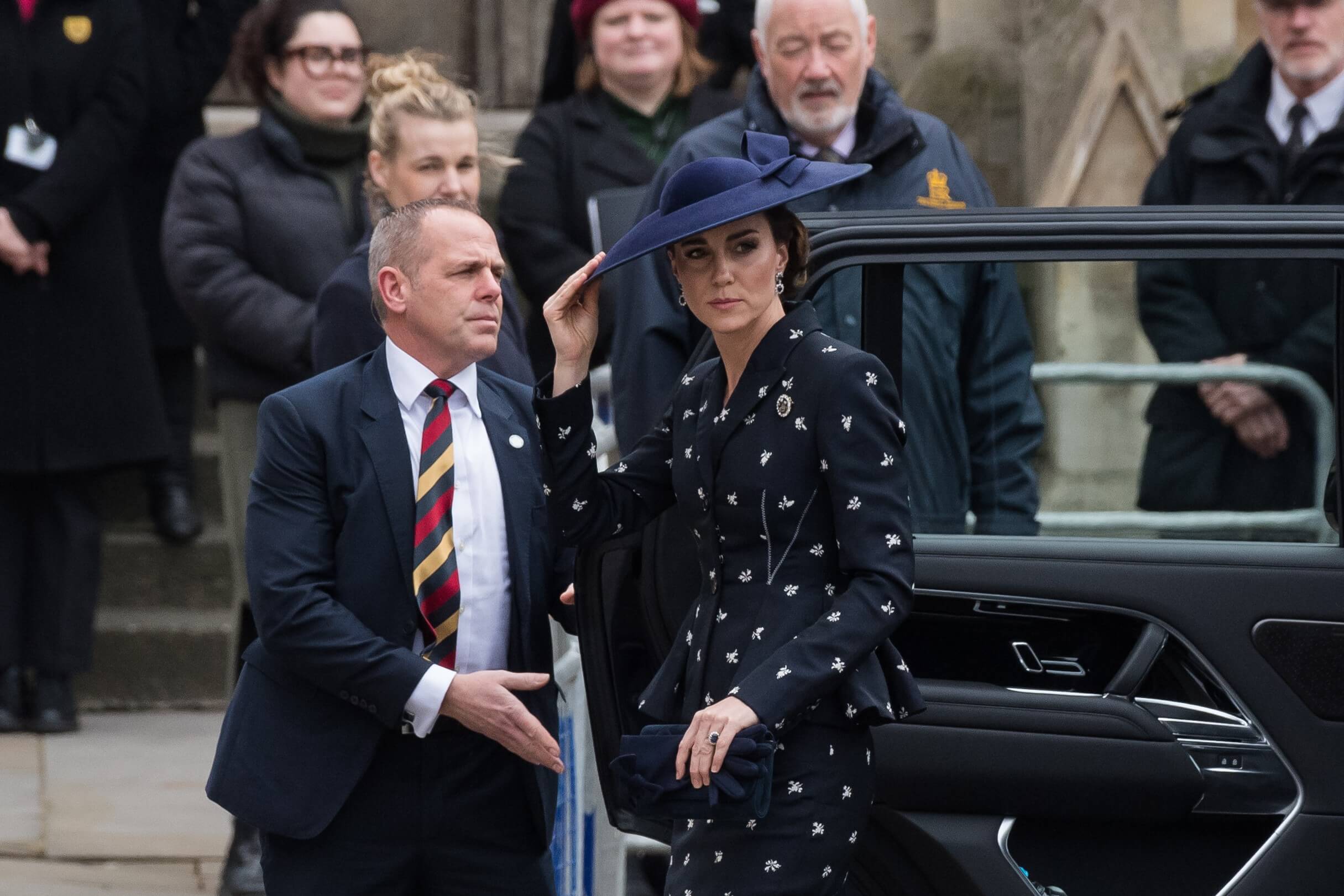 Kate Middleton wears a navy suit with a white floral pattern during the Commonwealth Day service.