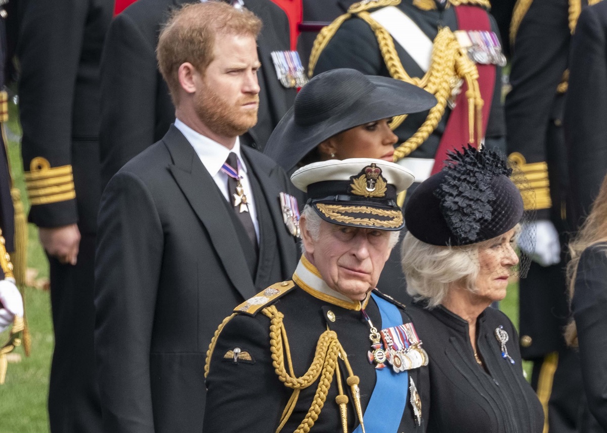 King Charles, Camilla Parker Bowles, Prince Harry, and Meghan Markle watch as Queen Elizabeth II's coffin leaves in the state hearse