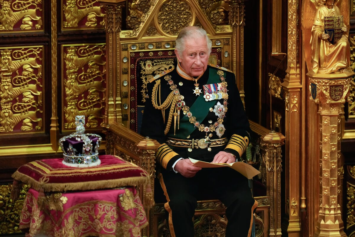 King Charles III, then Prince Charles, Prince of Wales reads the Queen's speech next to her Imperial State Crown in the House of Lords Chamber, during the State Opening of Parliament in the House of Lords at the Palace of Westminster on May 10, 2022 in London, England