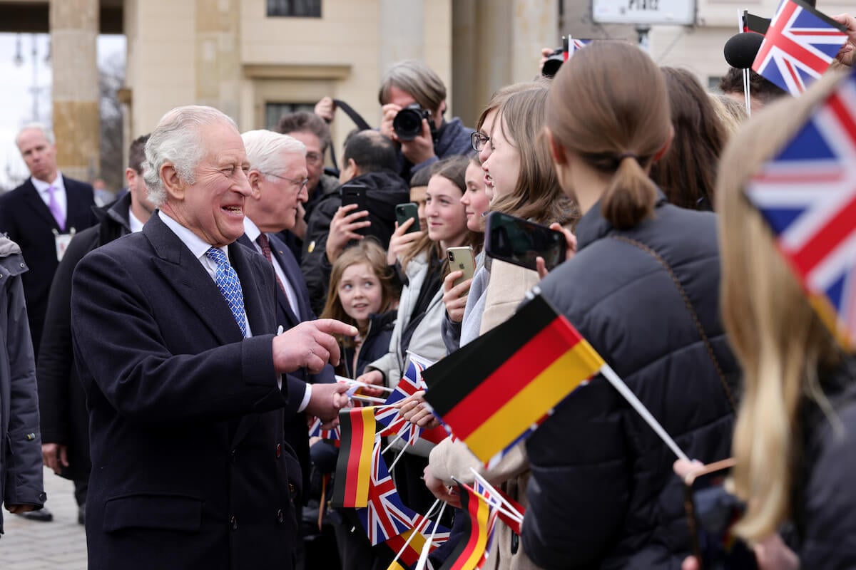 King Charles, who picked up a man's hat during Berlin walkabout in similar move to Princess Diana, Kate Middleton, and Meghan Markle, per body language expert, during state visit to Germany