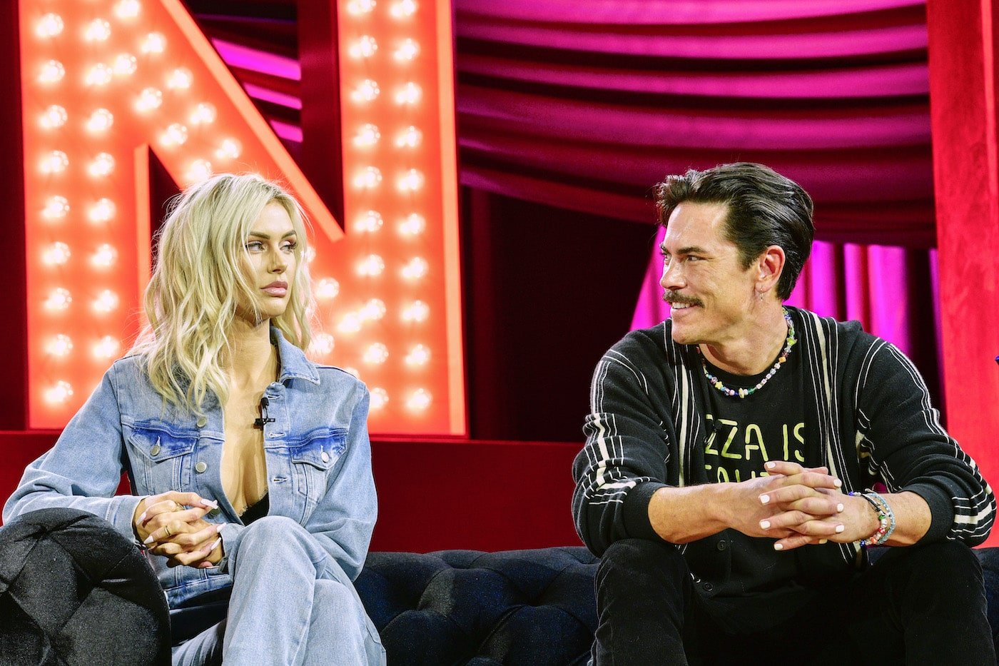 Lala Kent looks at Tom Sandoval from 'Vanderpump Rules' while they sit on a couch at BravoCon