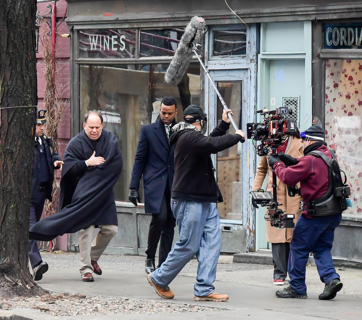 Actors filming a scene of 'Law and Order: SVU' with camera person in front of them and a microphone being held over them