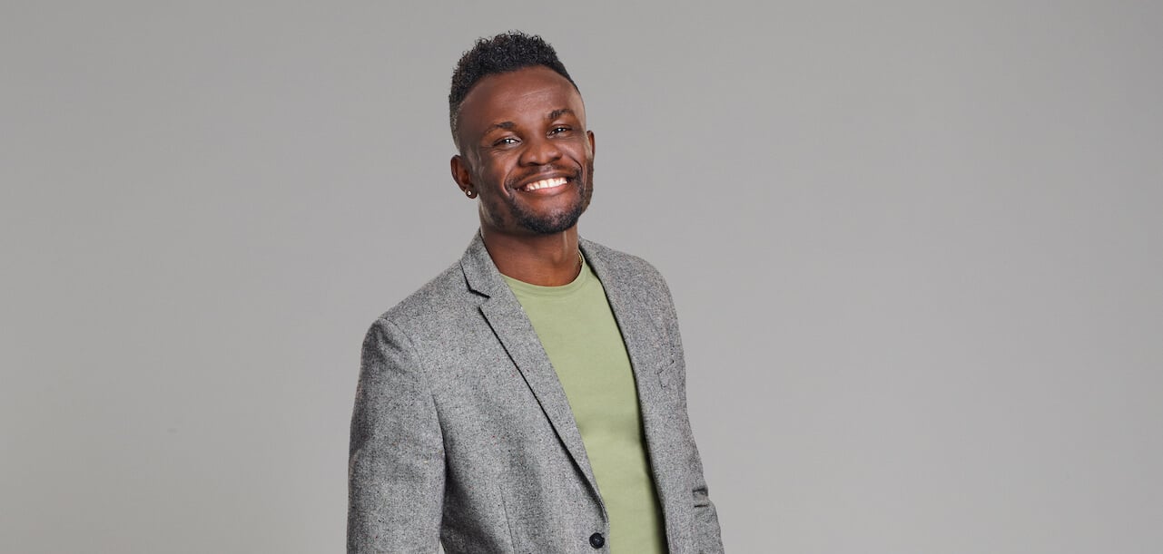 Kwame of 'Love Is Blind' Season 4 wears a green shirt and grey jacket.