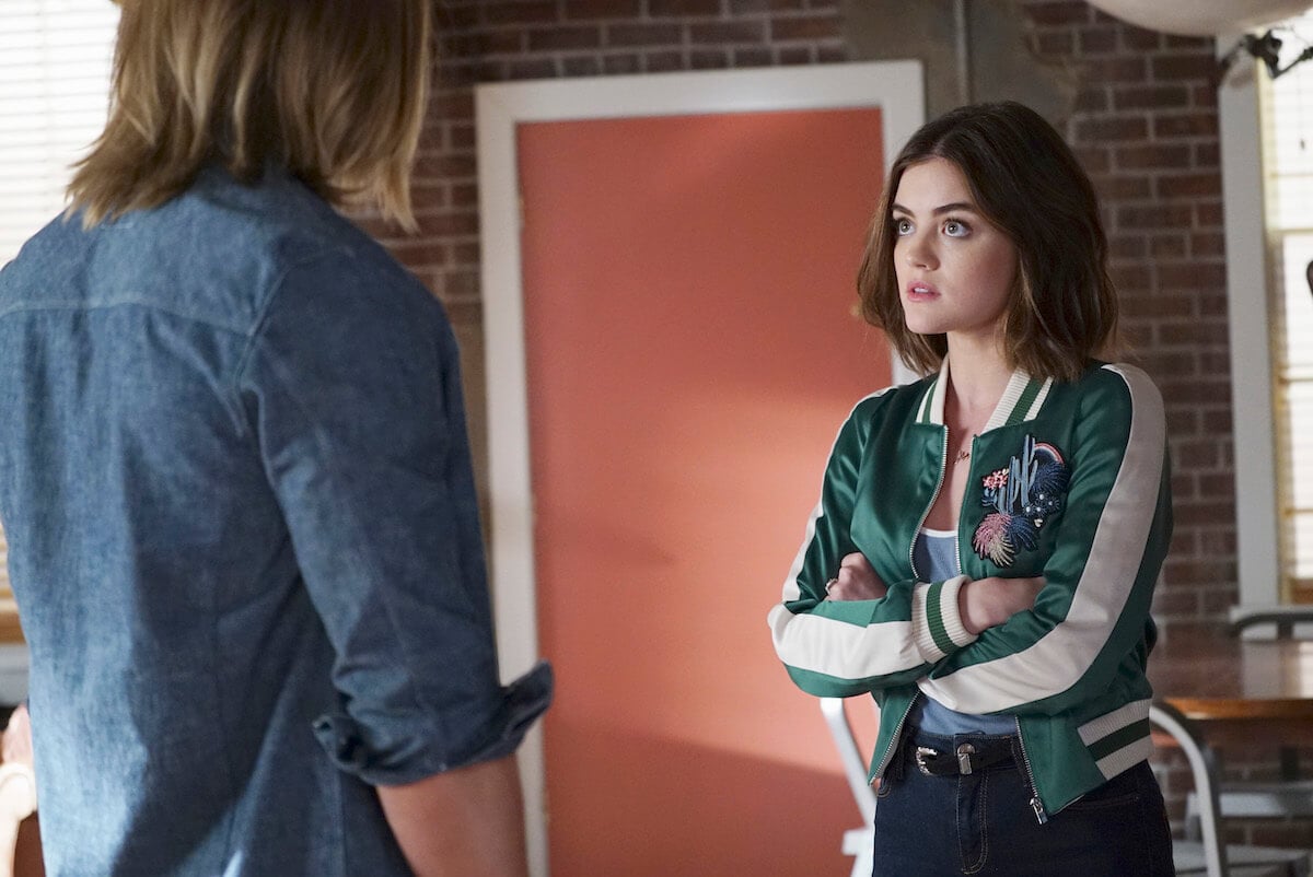 Lucy Hale crossing her arms and looking at another character in a scene from 'Pretty Little Liars'
