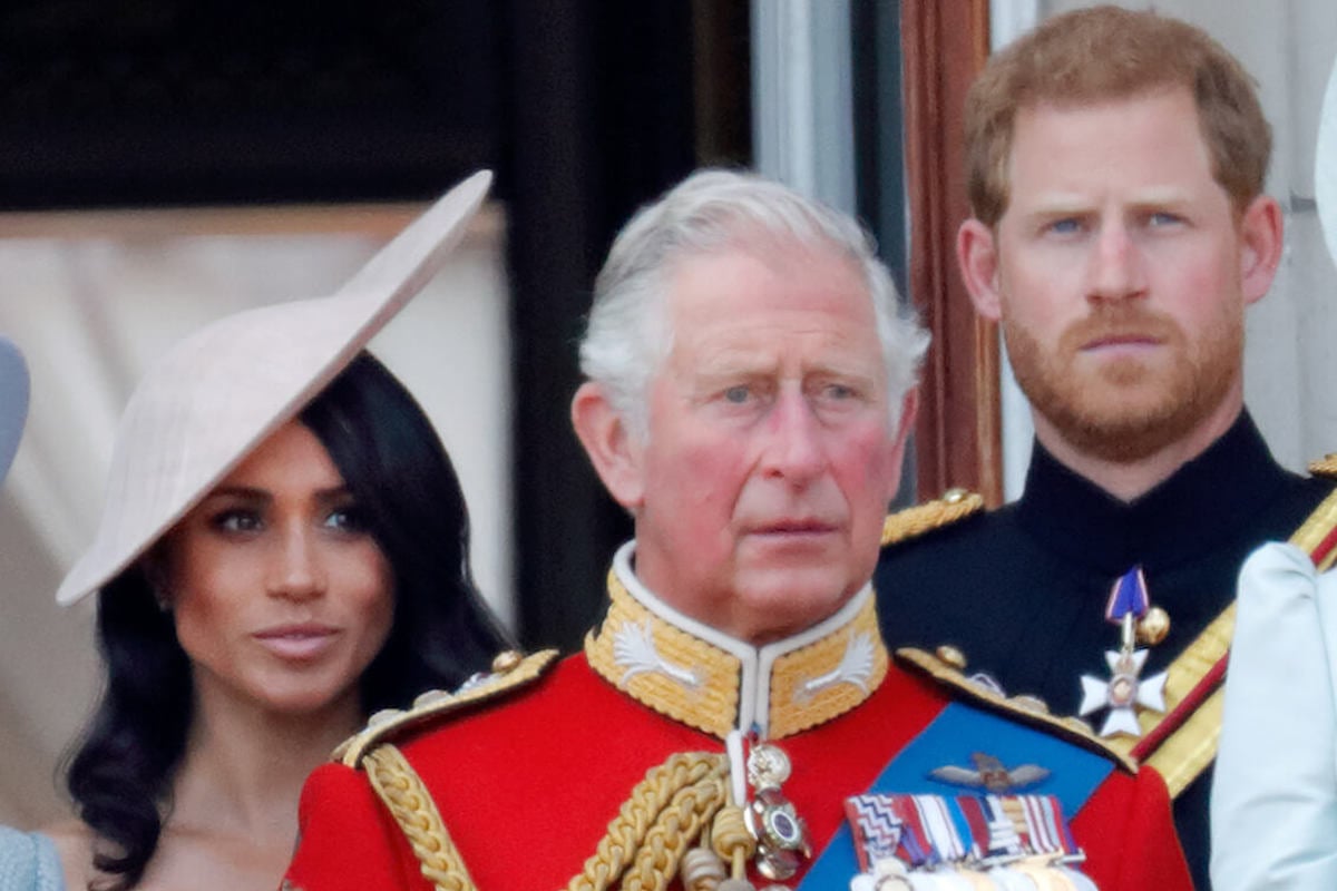 Prince Harry and Meghan Markle, whose not sharing their RSVP to the coronation has been dubbed 'childish,' look on standing behind King Charles