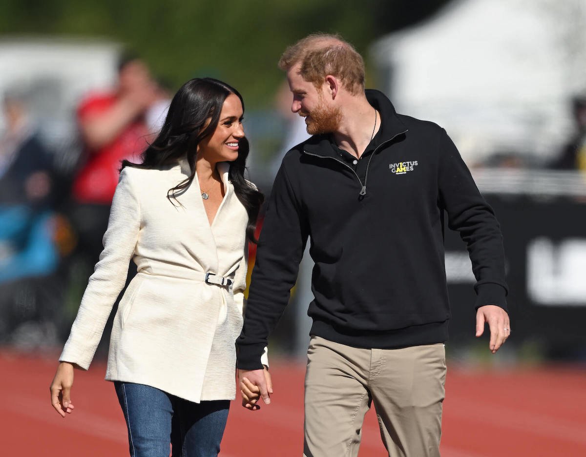 Meghan Markle and Prince Harry holding hands, smiling